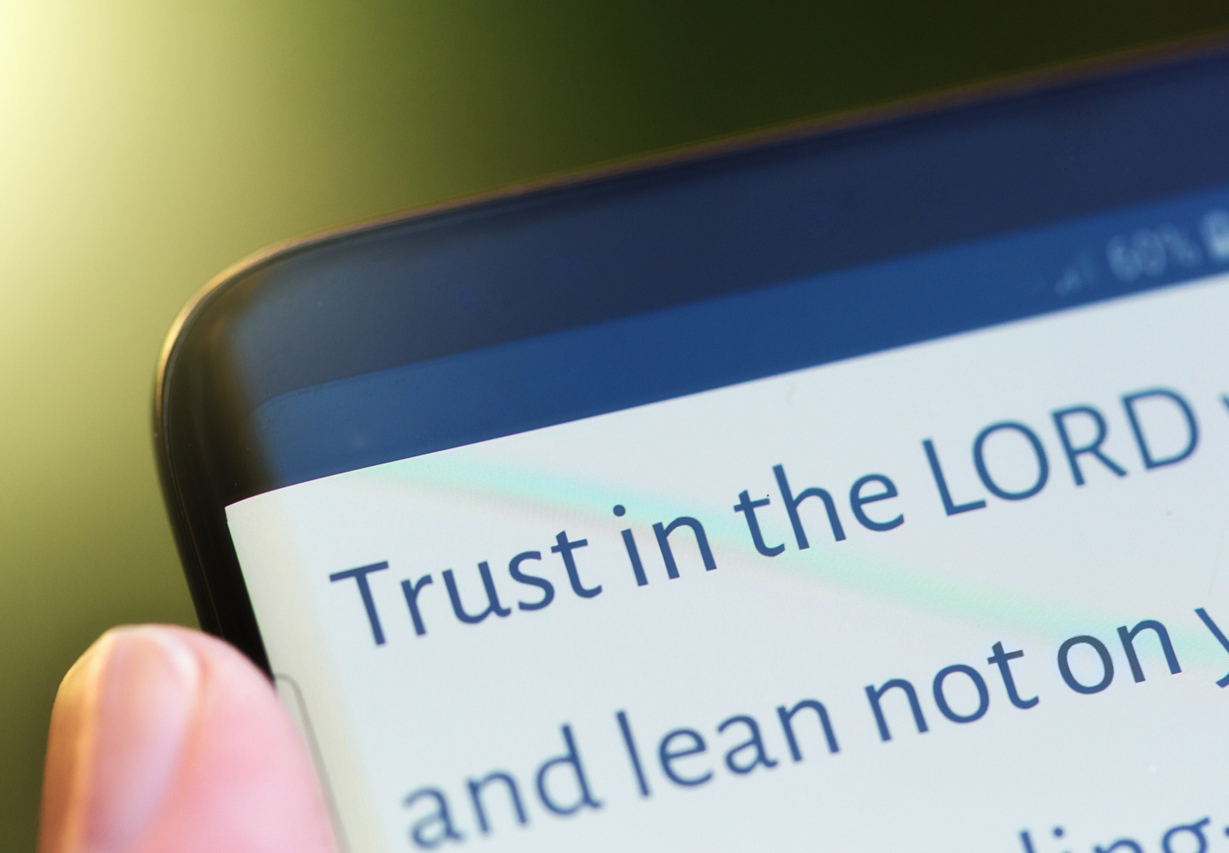 "Trust in the LORD" message on mobile phone A mobile phone message or app shows an extract from Proverbs " Trust in the LORD...".